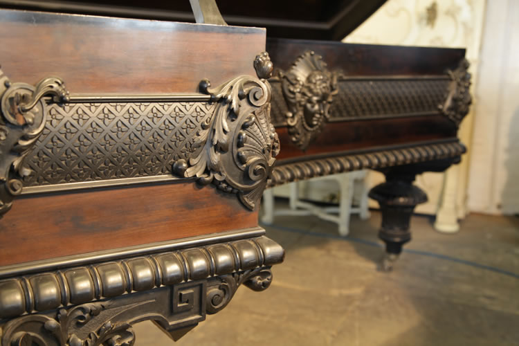 The high relief carvings of femail figure heads, feathers and acanthus  around this Bechstein model C piano cabinet are connected by a carved band of stylised flowers in a basketwork grid