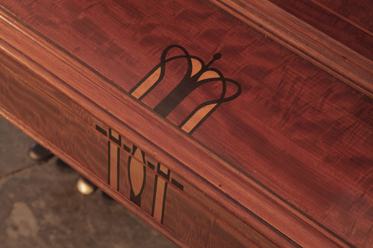 Piano fall inlay detail of a stylised crown and geometric shapes in contrasting woods