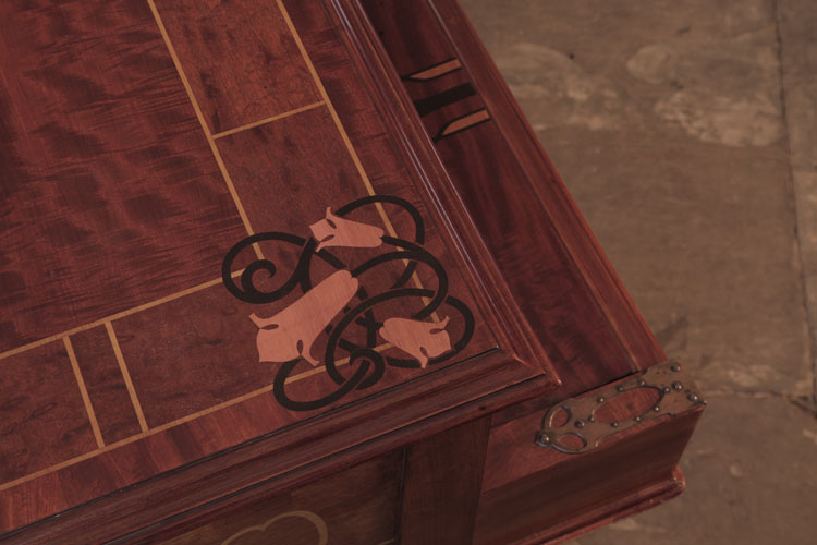 Piano lid corner inlaid with a repeating motif of stylised bellflowers, celtic knotwork and stringing in contrasting woods