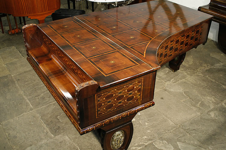Variety of marquetry inlay designs in coloured woods around the piano cabinet