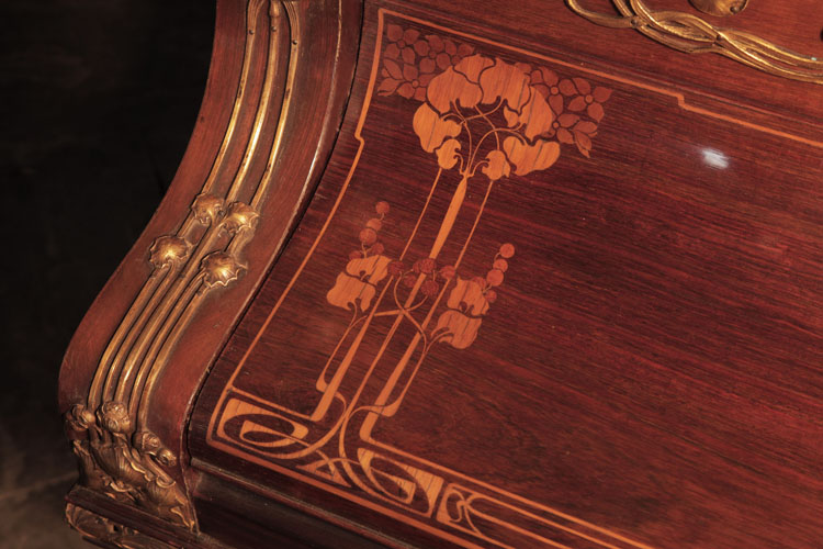 The piano fall is inlaid with a symmetrical Art Nouveau design of stylised foliage and whiplash lines in coloured woods