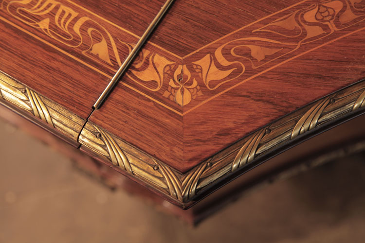 he piano lid is also inlaid with an Art Nouveau style border in a stylised rinceau of interlocking foliage and flowers in coloured woods.