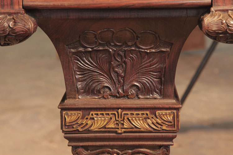 Each leg is a tapered, four-sided baluster shape, carved with sunflowers and foliage with a gilt filigree band
