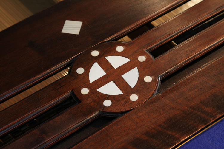 In the centre of the music desk is an inlaid circle with central cross.  Viewed as a Norse symbol, this suggests the sun wheel, one of the oldest spiritual symbols of the Germanic people. The central cross seperates the circle into four pieces, just like the seasons in a year. It is representative of life, fertility and peace