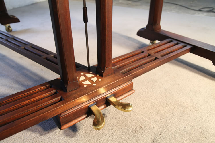 A slatted cross stretcher supports the gate legs and simple lyre on this Lipp piano. In the centre of the piano  lyre is repeated  the symbol of the sun wheel.