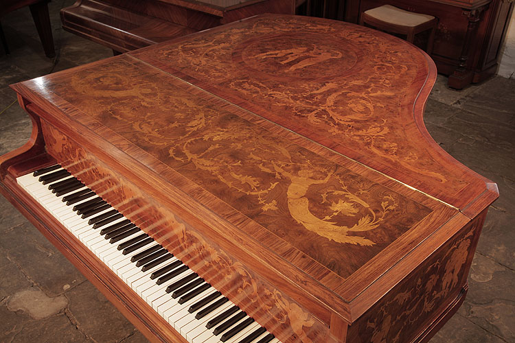 Piano lid inlaid with two floating half figures carrying aloft arabesques of scrolling foliage and hibiscus 