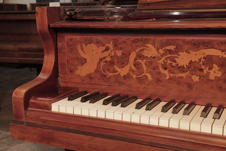 The piano fall is inlaid with hibiscus flowers and scrolling tendrils, flanked by winged cherubs 
