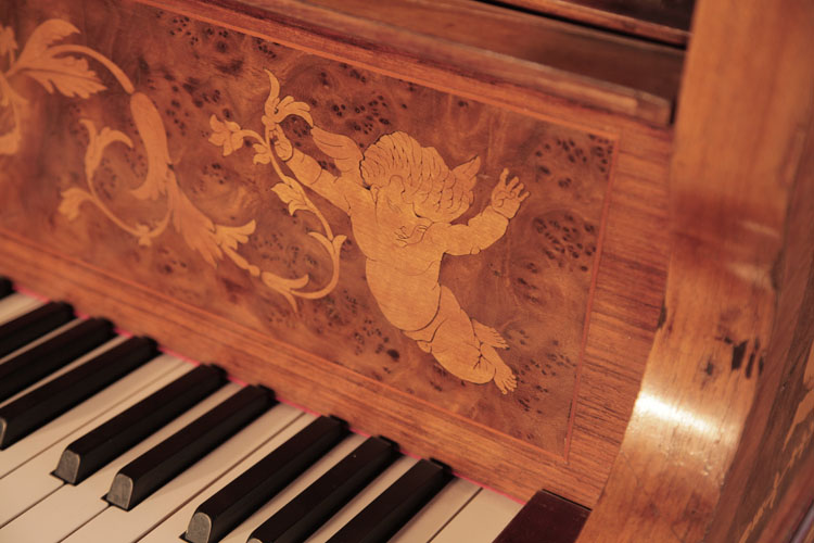 The piano fall is inlaid with hibiscus flowers and scrolling tendrils, flanked by winged cherubs 