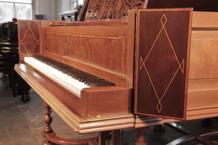 The square, high piano cheeks are hinged and fold out to allow the players hands to be visible. Cheeks inlaid in a diagonal, satinwood stringing design 