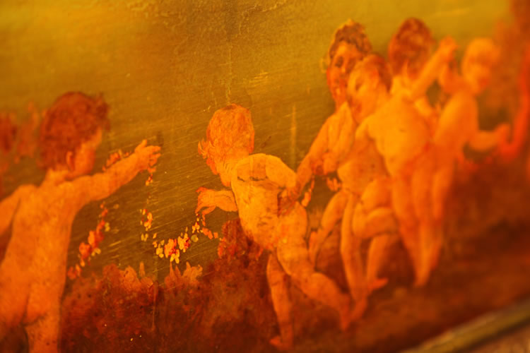 Hand-painted detail of dancing cherubs