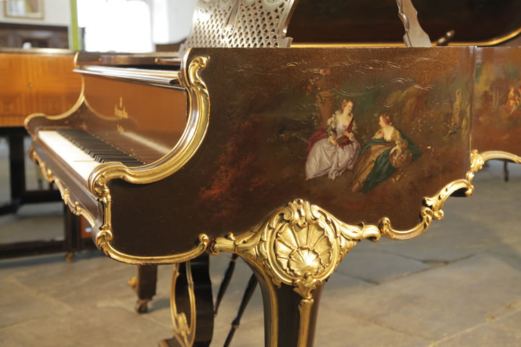 Steinway Model B ornately carved, piano cheek with gilt accents. The hand-painted scene features two ladies sitting outdoors discussing a book and gathering flowers in a basket