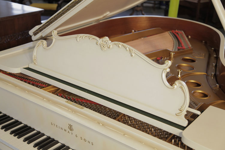 Steinway model O music desk in a  S-curve edged design with a carved, acanthus border and gilt accents