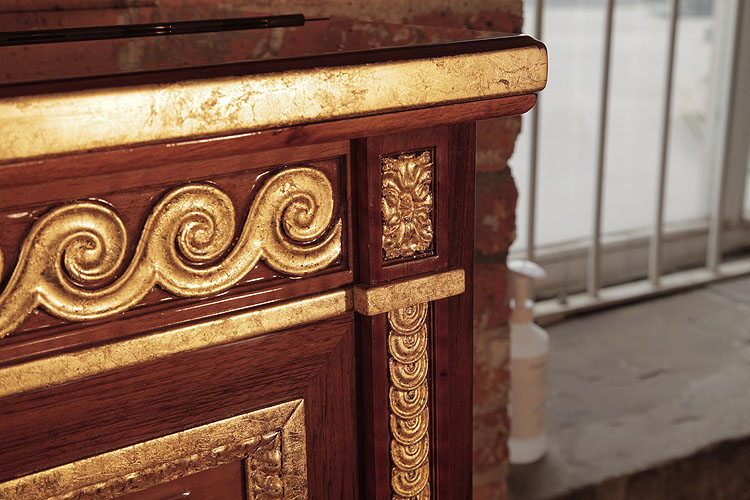 Steinway carved rolling waves detail in gold