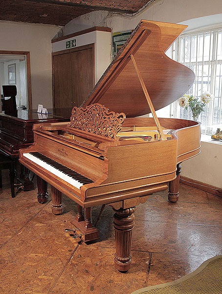 Rebuilt, 1900 Steinway Model A grand piano with a walnut case, filigree music desk and fluted, barrel legs with gadrooning detail.