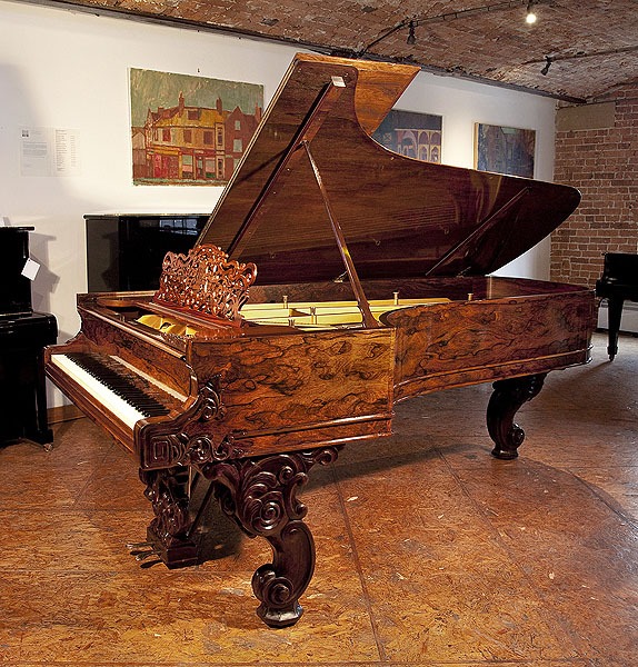 A stunning, 1877, Steinway & Sons Model D concert grand piano with an exquisite wood case and reverse scroll legs. Cabinet features piano cheeks carved with scrolling foliage 