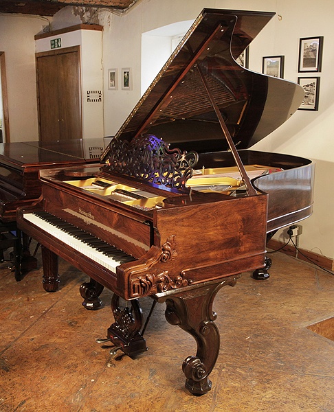 Rebuilt, 1877, Steinway Style 1 grand piano for sale with a french polishedrosewood case. Cabinet features carved, Rococo styling and scroll foot legs. Piano has an eighty-five note keyboard and a two-pedal lyre. 